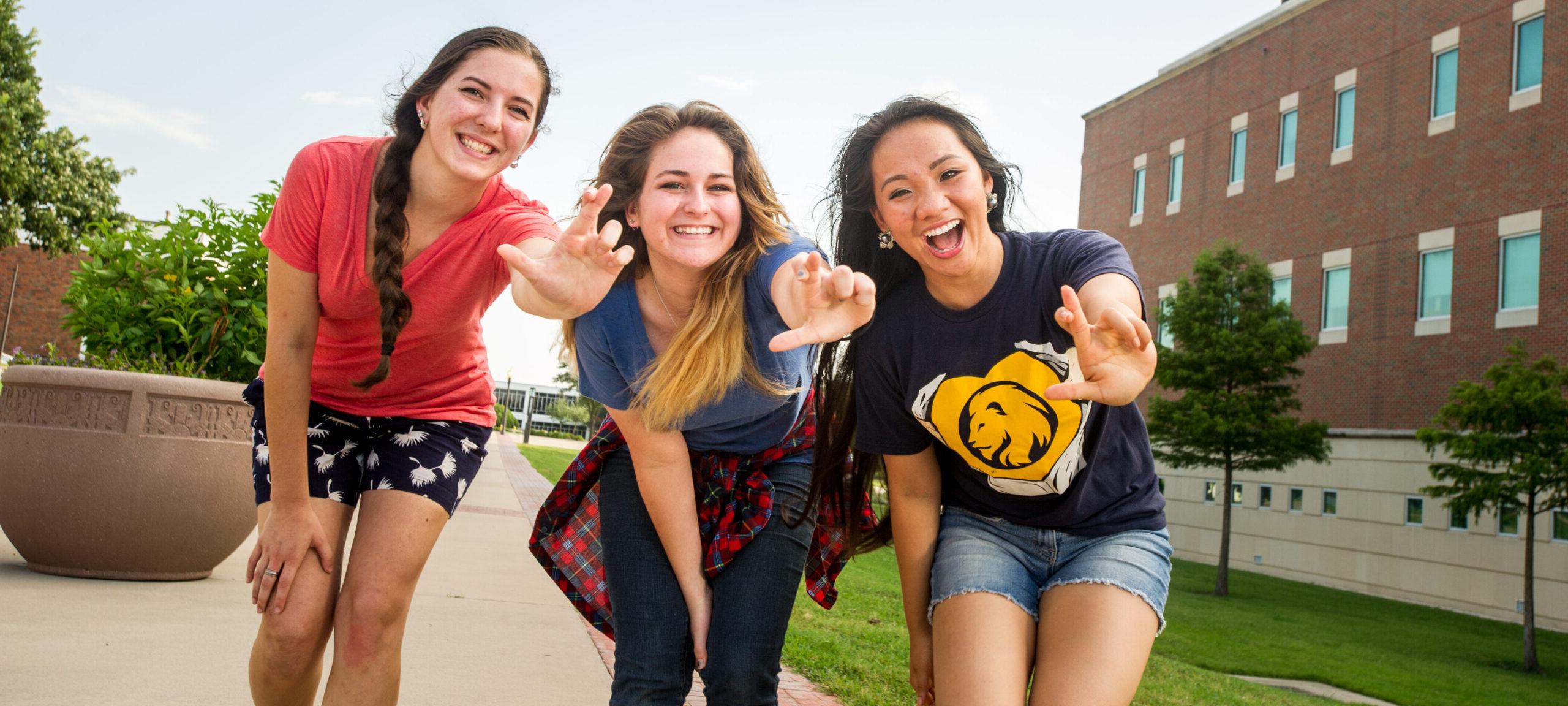 三名女学生微笑着展示狮子座的手势.